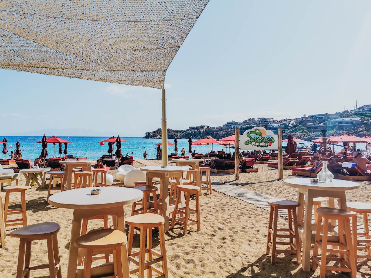 A photo of lost paradise in Mykonos, Greece with gold sand and clear blue water in view.